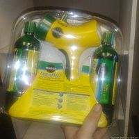Front view of sealed Miracle-Gro Liquafeed starter kit showing yellow sprayer and two nutrient bottles inside clear plastic packaging.