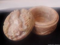 Open jar showing hollow interior and carved lid with lion relief