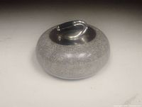 Miniature granite curling stone with metal handle shown on a white background.