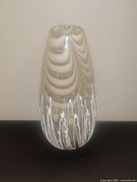 Front view of a clear blown glass vase about 15 inches tall, showing subtle curves and white decorative swirl lines inside glass