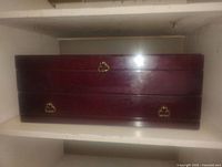 Front view of the vintage wooden mahogany cutlery box showing two drawers with gold-tone handles.
