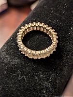 Close-up view of silver tone cocktail ring on black velvet holder, showing rectangular block pattern all around the band.