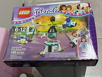Front view of the LEGO Friends 41128 Amusement Park Space Ride box showing set details, piece count, and Olivia mini-doll figure illustration.
