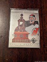 Front of the card showing Martin Brodeur in goalie gear with Vezina Trophy image and embossed texture