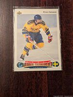 Front photo of 1992-93 Upper Deck Peter Forsberg World Junior rookie hockey card depicting Forsberg skating in yellow and blue Swedish uniform with World Junior Tournament logo.
