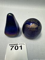Both art glass paperweights together on white background, showing round and teardrop shapes with blue and gold luster finishes.