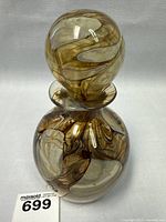 Full view of the Mdina Glass perfume bottle with stopper showing the swirling brown, amber, and white pattern.