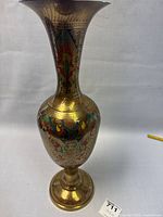 Full view of tall brass vase with flared rim and detailed colorful enamel floral designs
