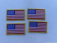 Four American flag patches with yellow border, arranged in a 2x2 layout on a gray surface