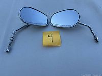 Pair of Harley-Davidson oval motorcycle mirrors with chrome stems, shown side by side on a flat surface.