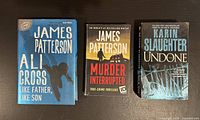 Photo showing front covers of three paperback books: two by James Patterson and one by Karin Slaughter. The covers display wear indicating they have been read and handled.