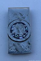 Single rectangular metal money clip with floral engraving and circular inlay showing Native American chief.