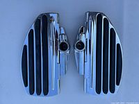 Pair of chrome motorcycle floorboards with black rubber inserts on top, showing mounting points and overall condition.