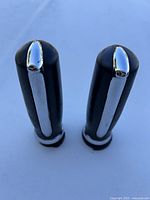 Top view of the two black motorcycle handle grips showing chrome strip and end caps.