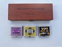 Closed wooden cigar box labeled 'Pre-Castro Cuban Cigars Series 1958' with three colorful Hallmark party match boxes placed in front.