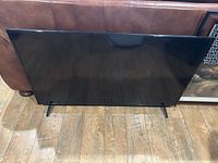 Front view of the 47 inch Vizio TV placed on the floor, showing the flat screen and black bezel.