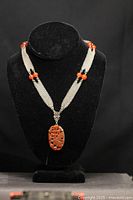 Front view of the Art Nouveau mesh choker collar necklace displayed on a black bust, showing the silver-tone woven mesh band, red glass beads, and carved red pendant.