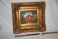 Front view of framed artwork showing ornate gold-toned frame and strawberry still life image