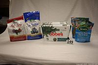 Full view of all fertilizer and plant food items in lot: 3 packs of Jobe's Fertilizer Spikes, Espoma Holly-Tone and Soil Acidifier bags, and 2 Scotts Evergreen Flowering Tree & Shrub Food bags.