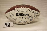 Full view of the Wilson NFL football showing multiple signatures on the white panel, including Dan Marino.
