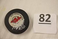 Top side of the puck showing New Jersey Devils logo and Martin Brodeur signature with jersey number 30.