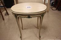 Full front view of the oval vintage table showing overall shape, legs, and paint condition.