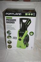 Full view of sealed box showing Portland Electric Pressure Washer with model specifications and branding.