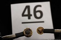 Two American Legion pins shown side-by-side with lot number 46 in the background for scale.