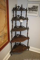 Full view of the five-tier Victorian corner display shelf showing overall shape and detailing
