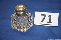 Photo of vintage Fostoria style swirl glass inkwell with silver-plated lid closed, showing tarnishing and wear on lid.