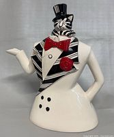 Front view of ceramic coffee pot shaped as tuxedo jacket with cat head and top hat