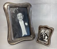 Two vintage sterling silver photo frames shown together featuring black and white vintage style photos inside, displayed standing upright.