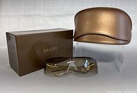 Sunglasses displayed with original hard case and box