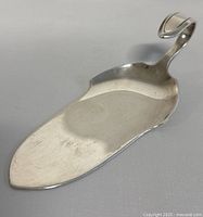 Angled front view of the silver plate pastry server showing the blade and curled handle