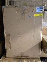 Photo of the sealed cardboard box containing the Adelaida nightstand to show original packaging and new condition