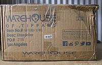 Damaged original shipping box for Warehouse of Tiffany chandelier, showing handling wear and tear.