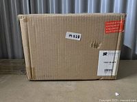 Sealed cardboard box labeled with Golden Lighting brand and model number 1945-1W WHT, containing one piece of the Axel wall sconce in matte white.