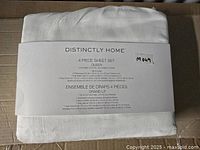Folded white 4 piece queen sheet set with packaging label showing brand Distinctly Home and basic product details
