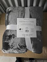 Photo of the folded Distinctly Home Duper Mink Blanket wrapped with a white ribbon and label showing product name and brand.