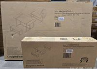 Two cardboard boxes one large and one smaller showing printed line drawing of table and benches