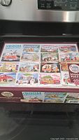 Puzzle box top showing various illustrated travel and camper scenes with the Cobble Hill brand and 2000 piece count