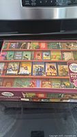 Puzzle box showing a bookshelf design with vintage books and various adventure illustrations, clearly indicating Cobble Hill brand and 2000+ pieces.