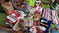 View showing various Christmas stockings, table cloth, ribbons, and cards on a green surface