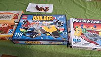 Photo showing four game boxes: Alhambra on left, LEGO Builder Xtreme center, Frustration right, and a partially visible board game on far left.