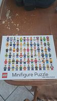 Front view of LEGO Minifigure Puzzle box showing the assembled image on the puzzle of multiple LEGO minifigures