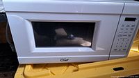 White Master Chef microwave with a black window and control panel on the right side.
