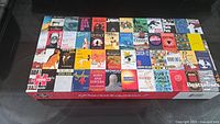 Box top displaying a grid of classic book covers on a 1000 piece puzzle