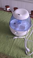 Image of the Vicks humidifier showing its translucent blue water tank and white base with cord extending from it