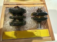 Two metal wood router bits in wooden case with bubble wrap protection