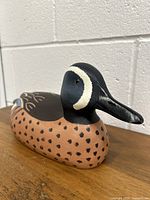 Photo showing side angle of wood duck decoy with detailed painted black, brown, white, and blue markings.